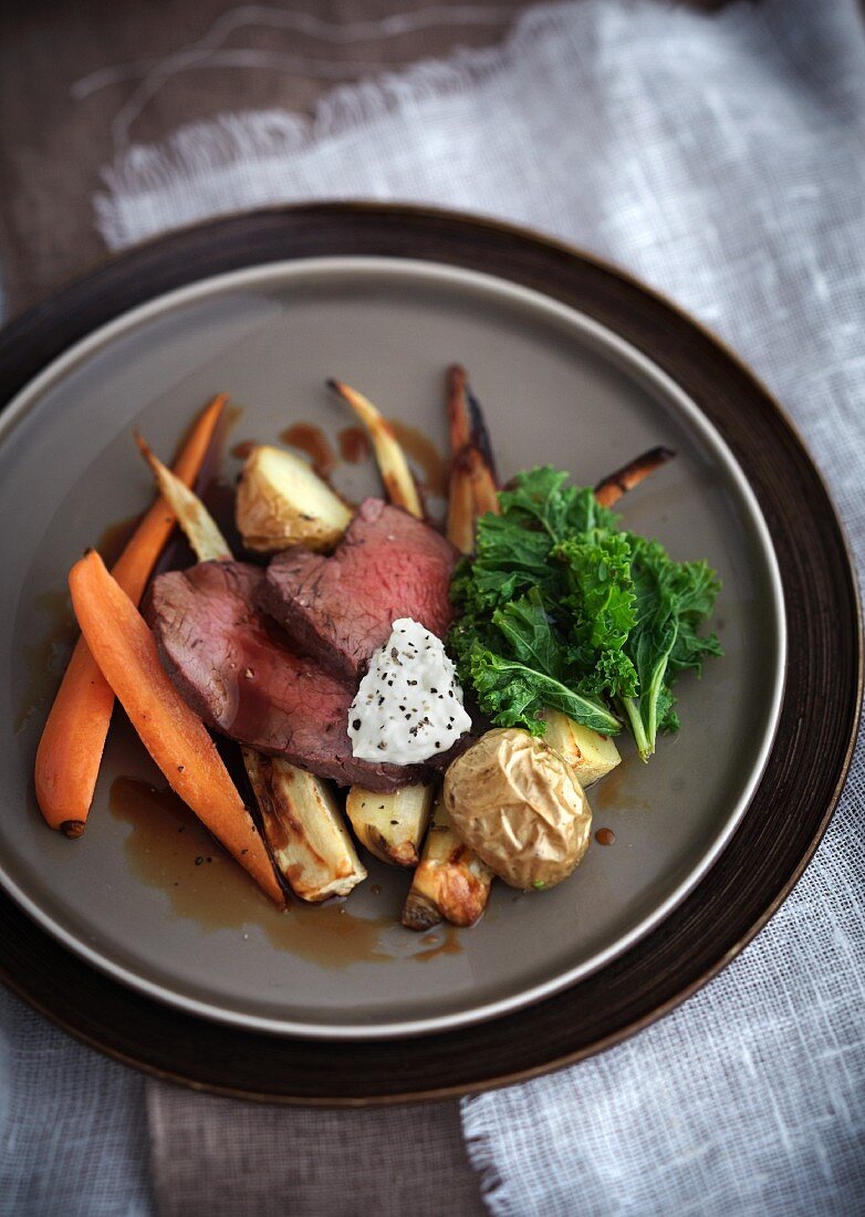 Roast beef on a bed of oven-roasted vegetables