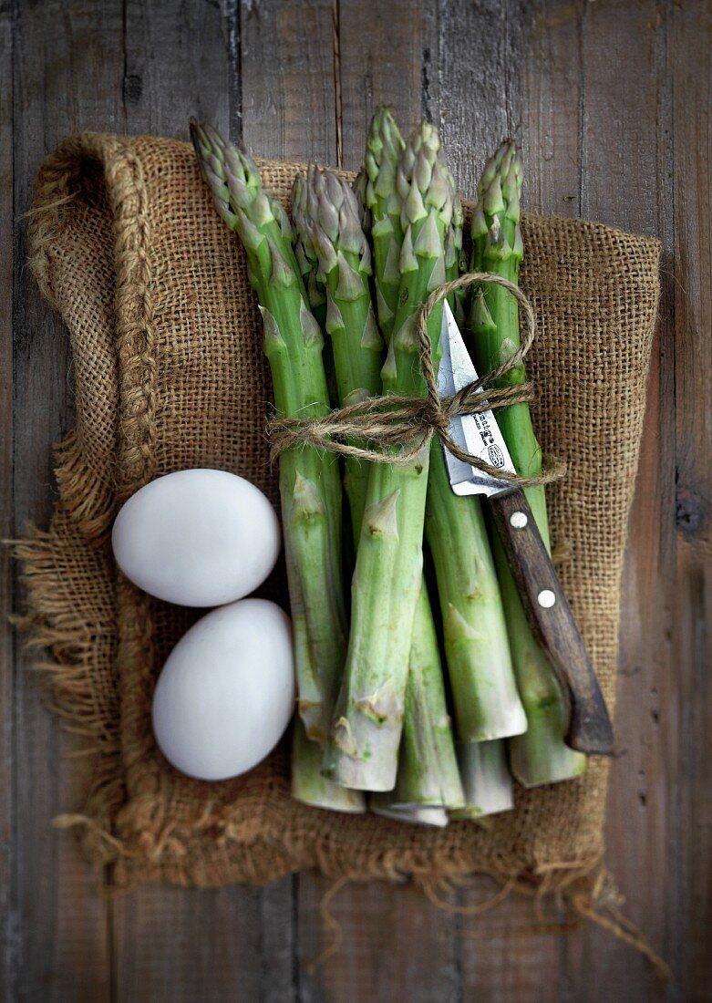 Green asparagus and eggs on a jute sack