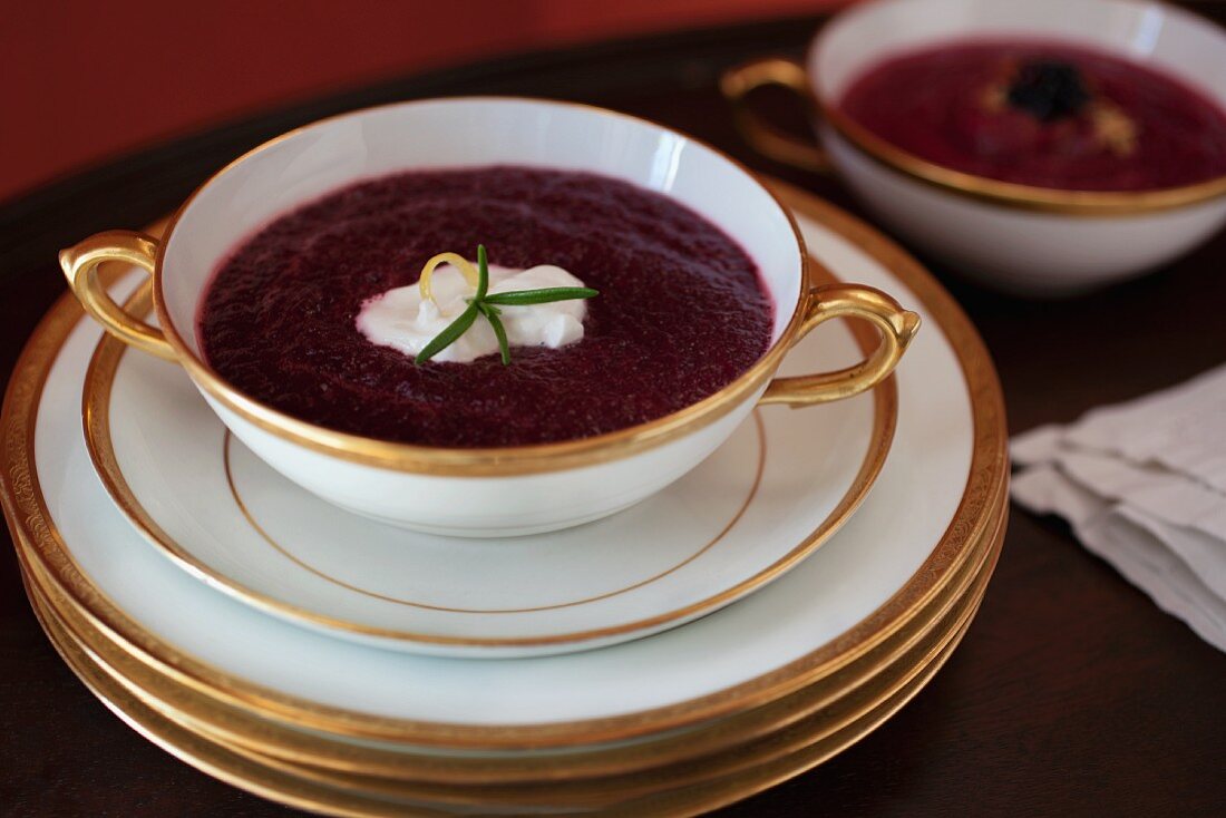 Borscht in an elegant porcelain soup cup with a golden rim