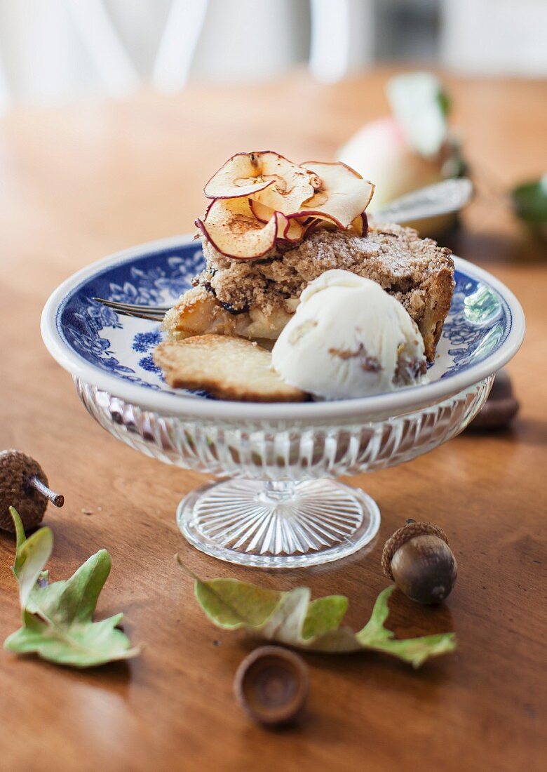 A slice of apple and almond cake with apple chips and walnut ice cream