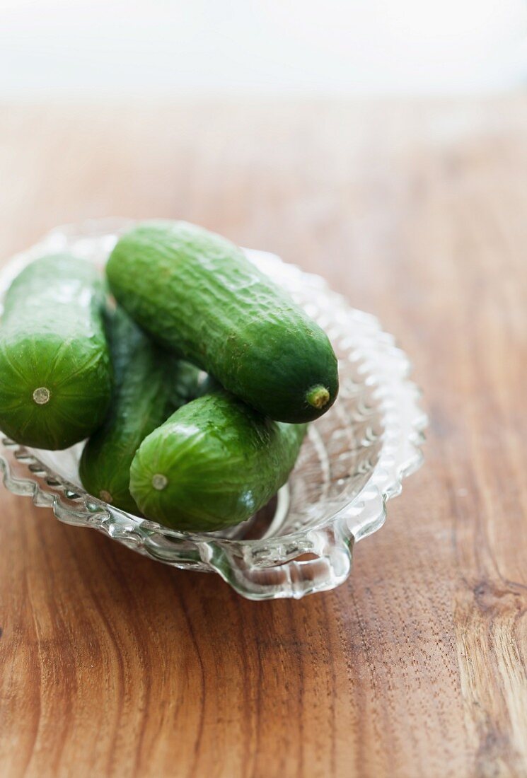 Fresh mini cucumbers in a glass bowl