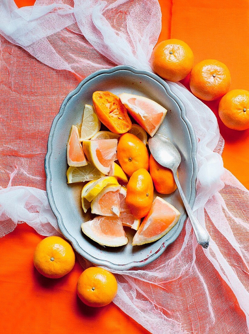 Rosa Grapefruitstücke, Zitrone, ausgepresste Orangen und Mandarinen