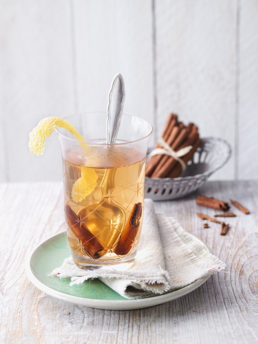 Mate tea punch with lemon zest and cinnamon sticks