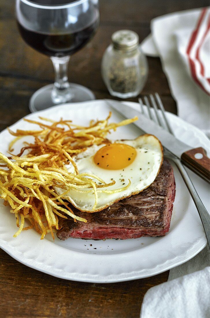 Beef steak with fried egg and potato straw