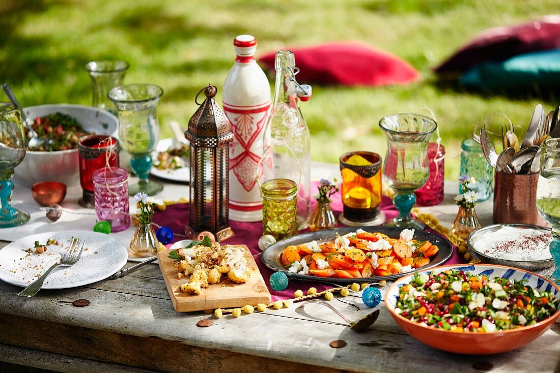 Marrokanische Sommerparty mit verschiedenen Speisen auf Gartentisch