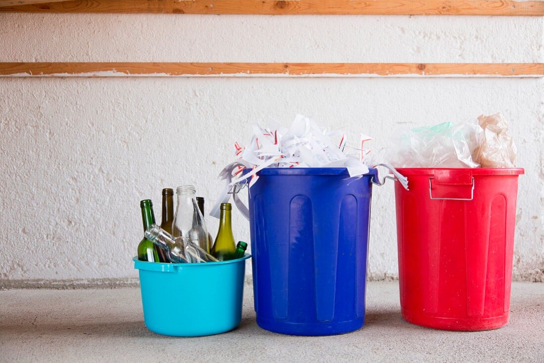 Waste separation: glass, paper and plastic in three different buckets