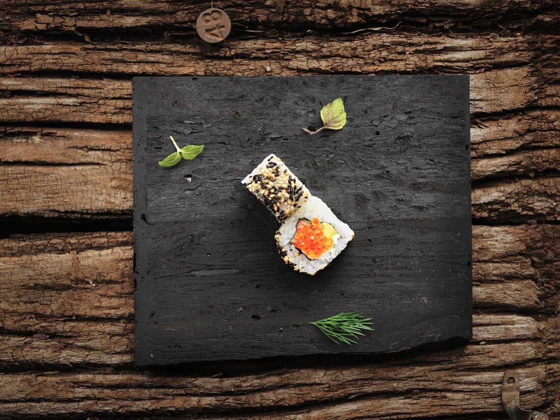 Uramaki with salmon, caviar and sesame seeds