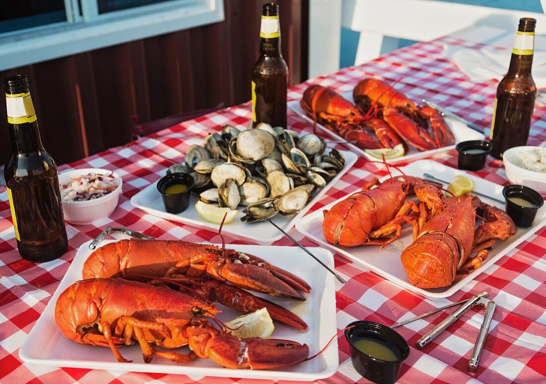 Gedeckter Tisch im Freien mit Lobster, Muscheln & Bier (USA)