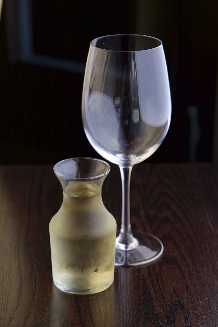 A carafe of white wine and an empty wine glass