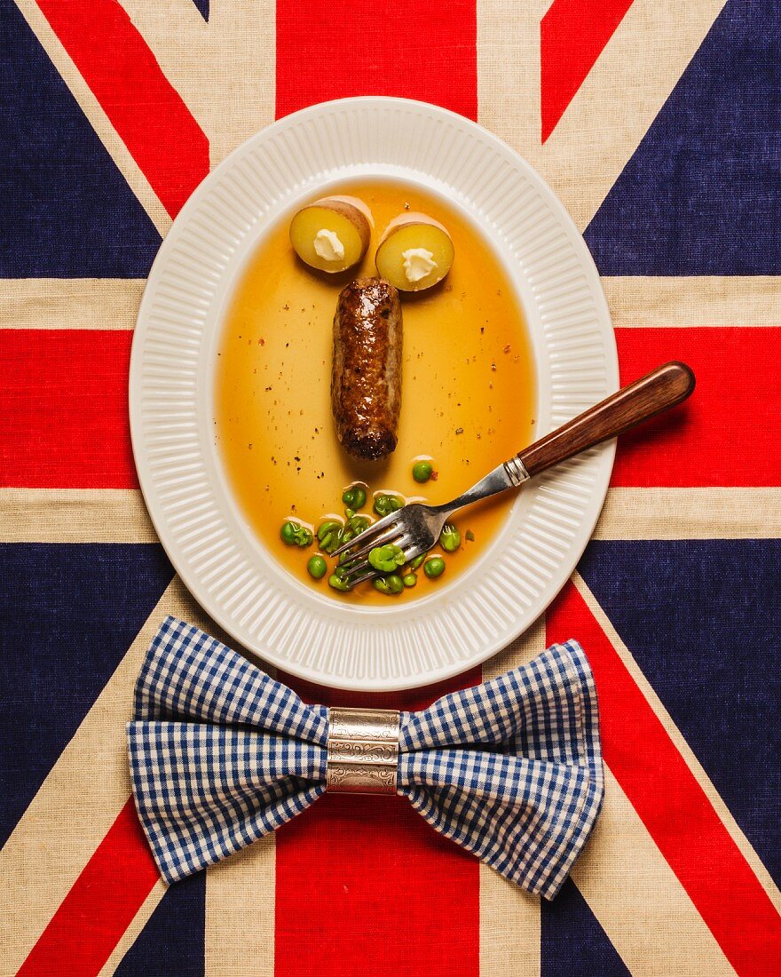 A face made from a sausage and vegetables on a Union Jack flag