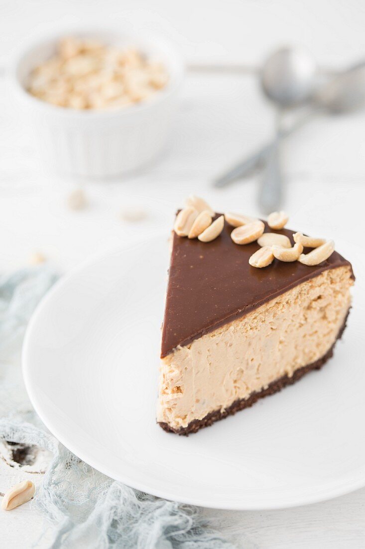 Ein Stück Karamell-Käsekuchen mit Schokolade & Erdnüssen