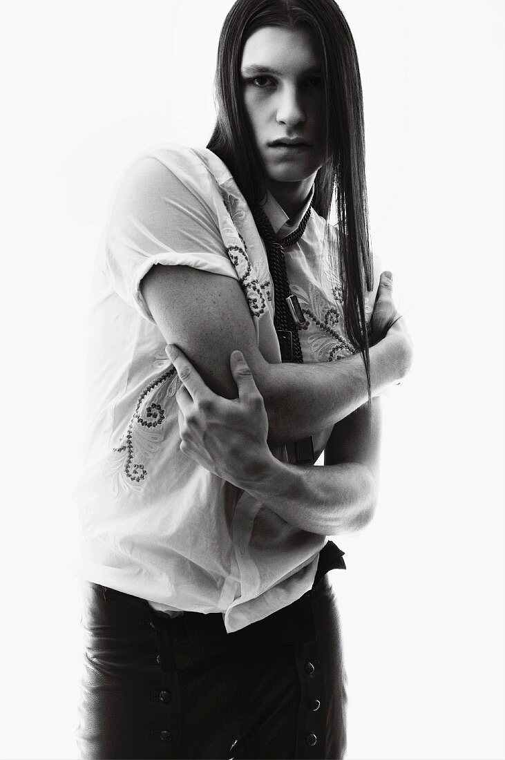 A young, long-haired man wearing an embroidered shirt (black-and-white shot)