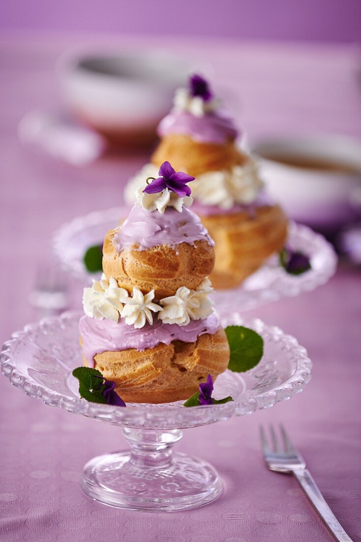 Religieuse with purple icing and cream flowers