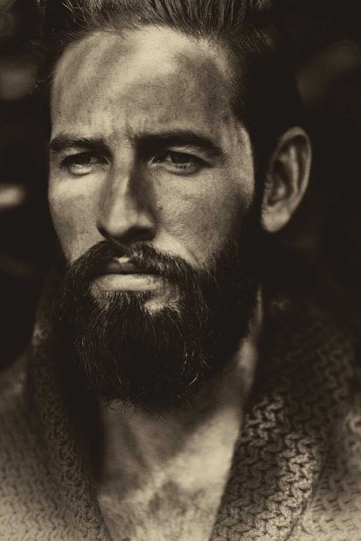 A portrait of a young man with a full beard