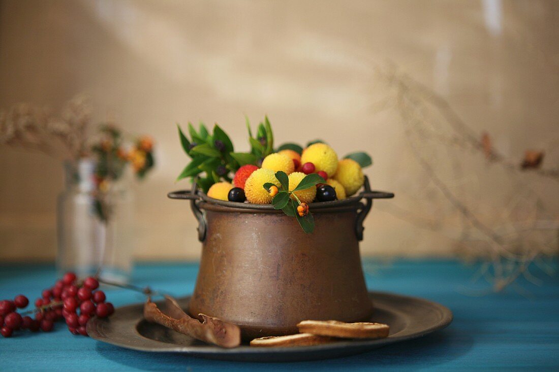 Strawberry tree fruits in an old copper pot