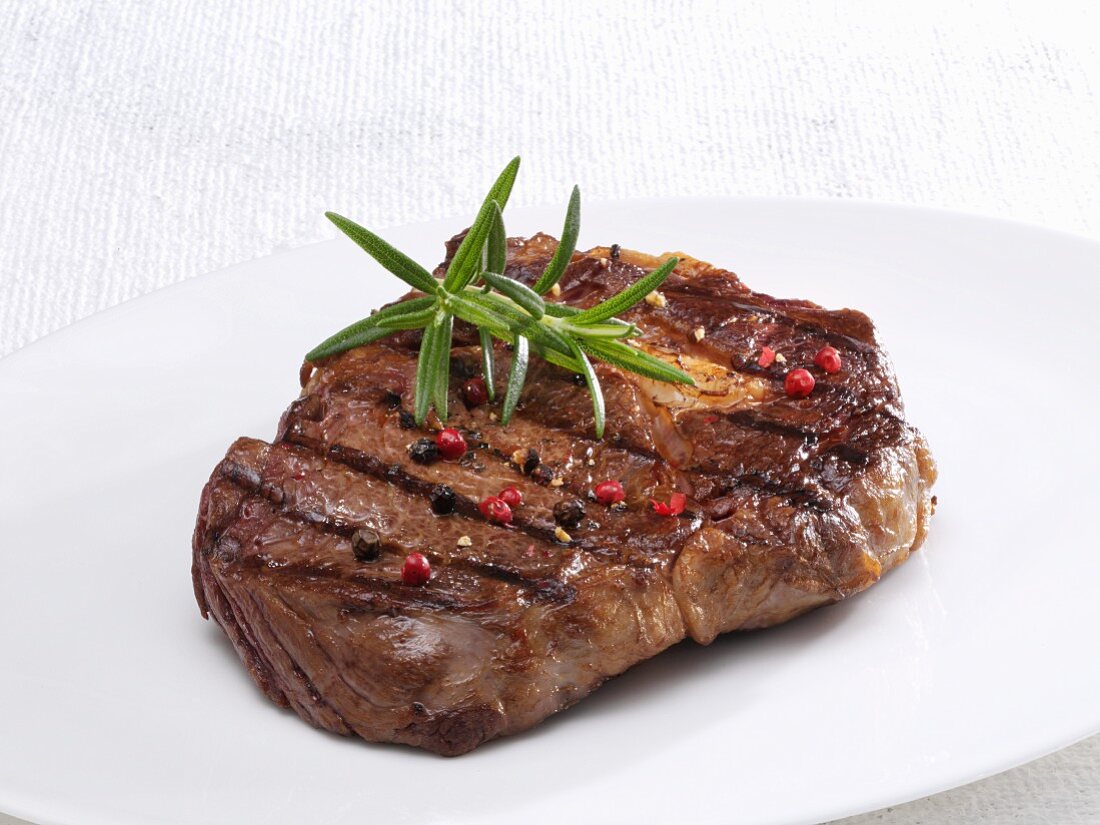 Beef ribeye steak with peppercorns and rosemary