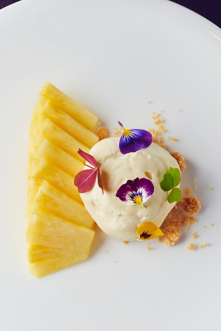 Pineapple with pepper cream, edible flowers and crumbles