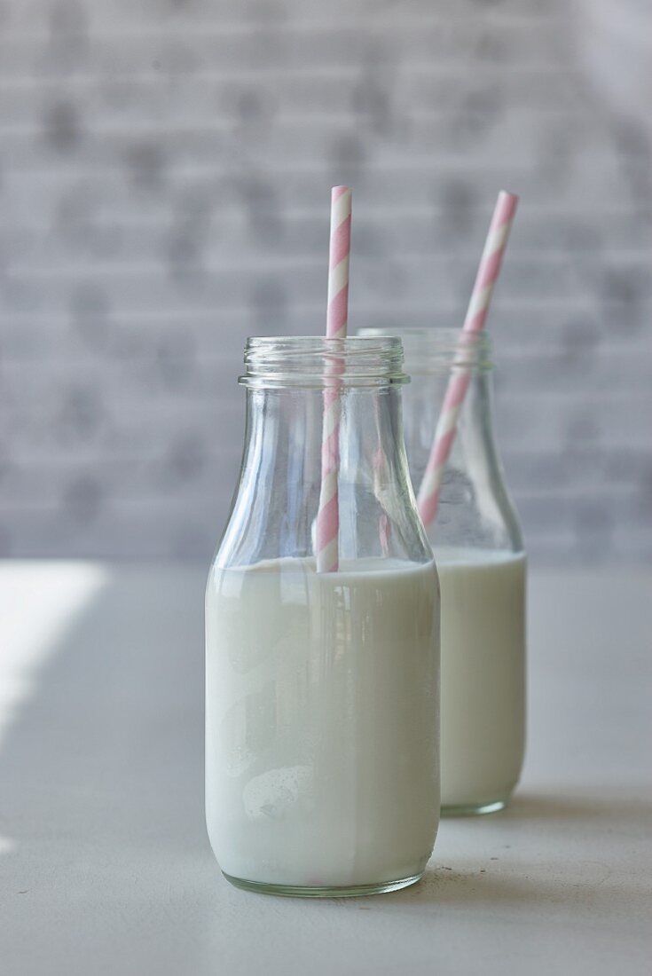 Bottles of milk with pink straws