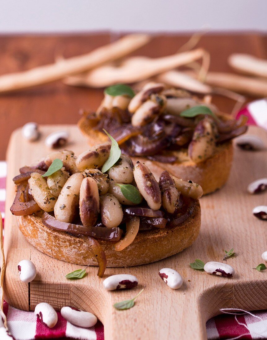Bruschetta topped with beans and onions