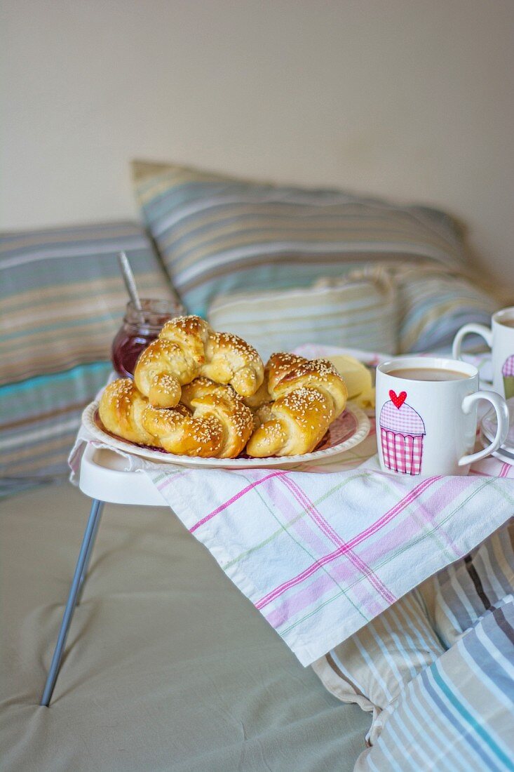 Frische Croissants mit Marmelade und Kaffee im Bett