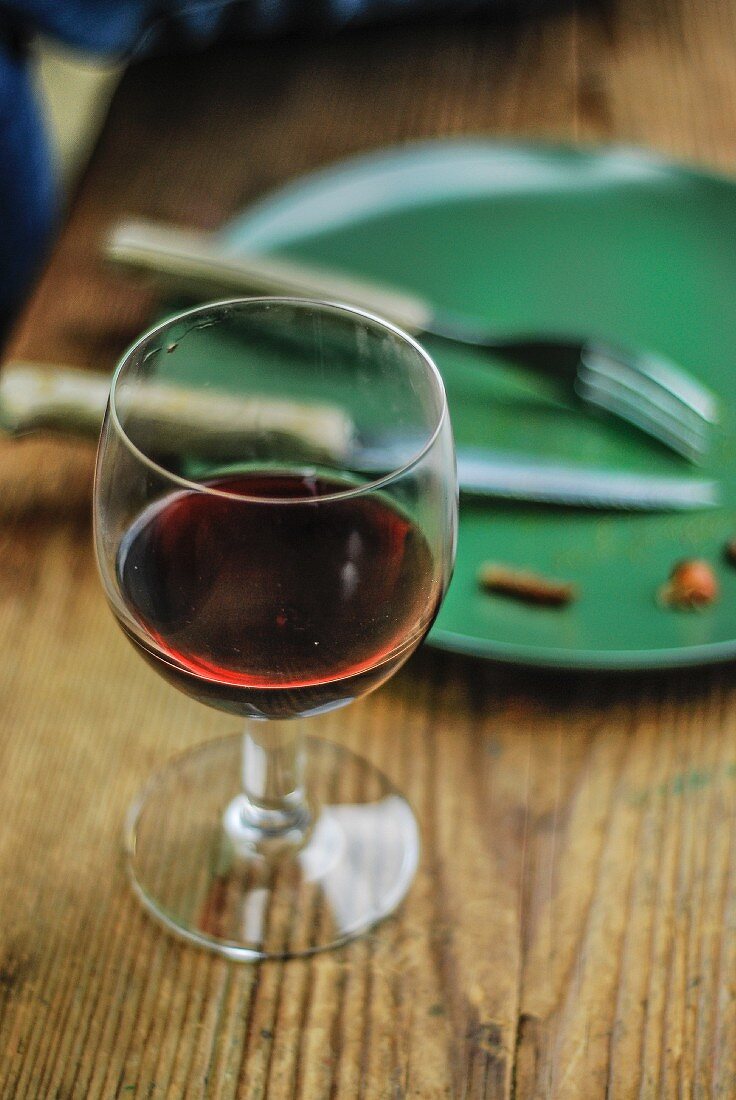 Ein Glas Rotwein neben leergegessenem Teller