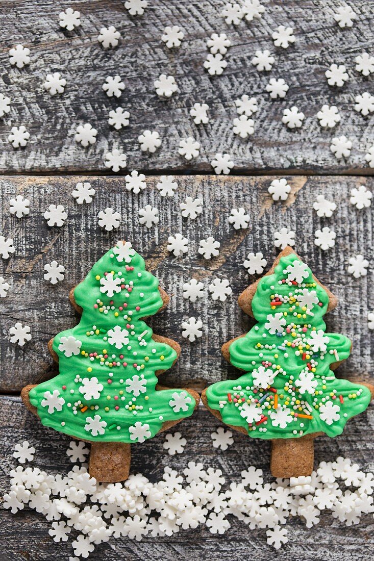 Lebkuchen-Weihnachtsbaum-Cookies mit grüner Zuckerglasur und Zuckerschneeflocken