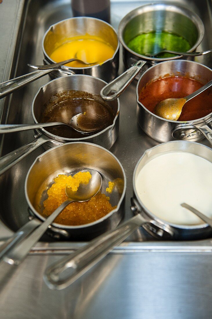Various sauces in pots in a restaurant kitchen