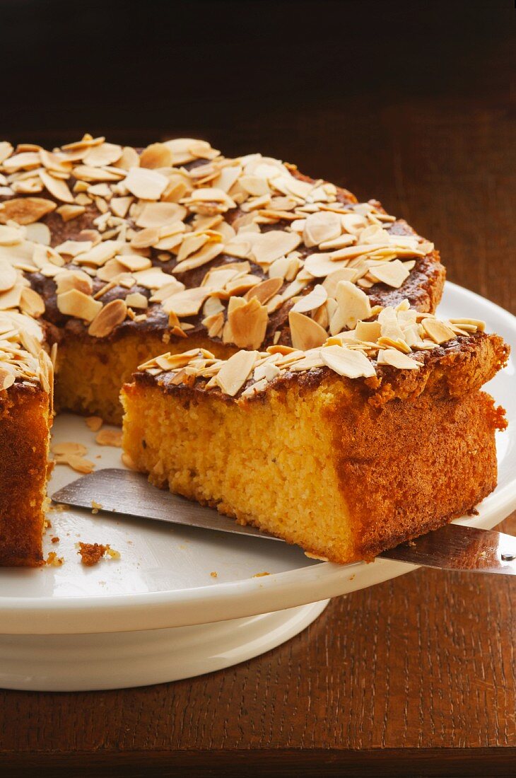 Mandarin cake with flaked almonds, sliced