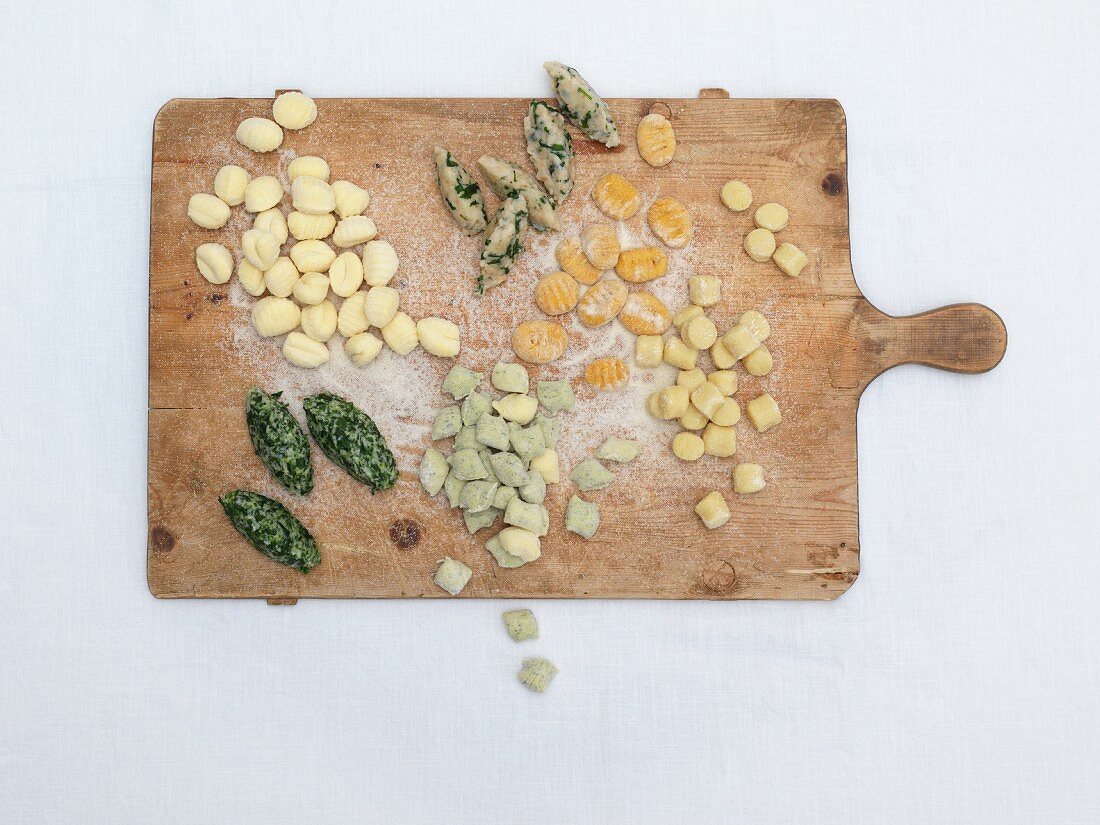 Various gnocchi on a chopping board