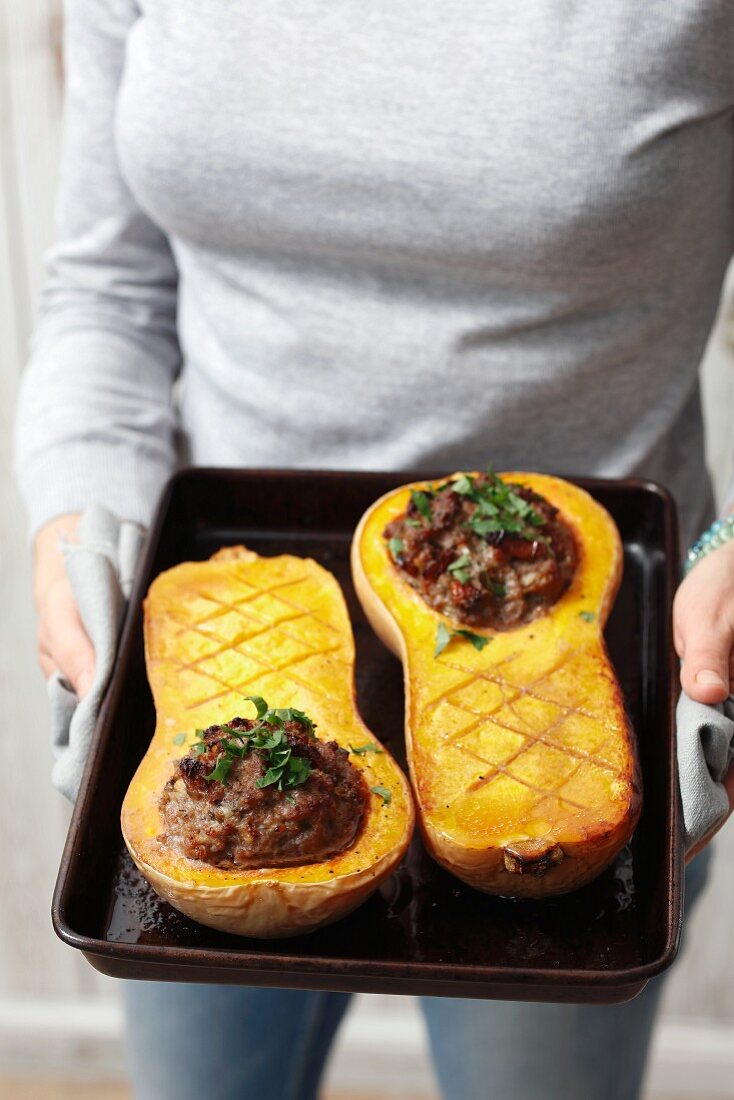 A woman with stuffed baked butternut squash