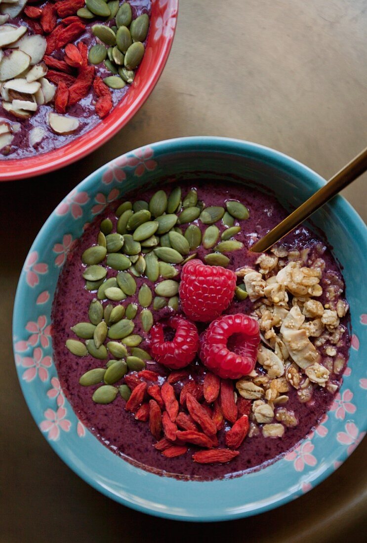 Acai smoothie in bowls with various toppings