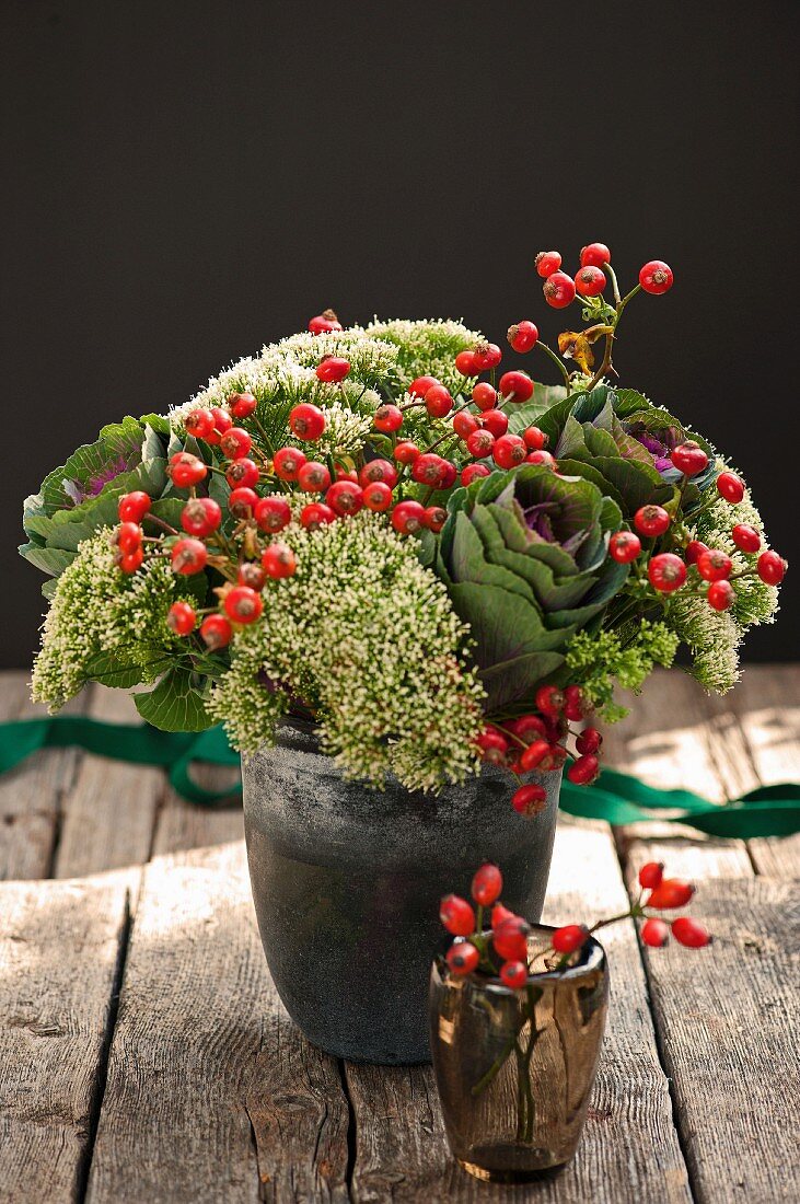 Herbstlicher Blumenstrauss mit Hagebutten in Vase