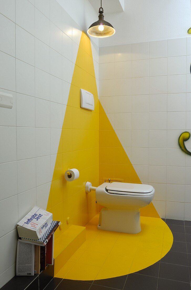 Toilet in white and yellow corner of bathroom
