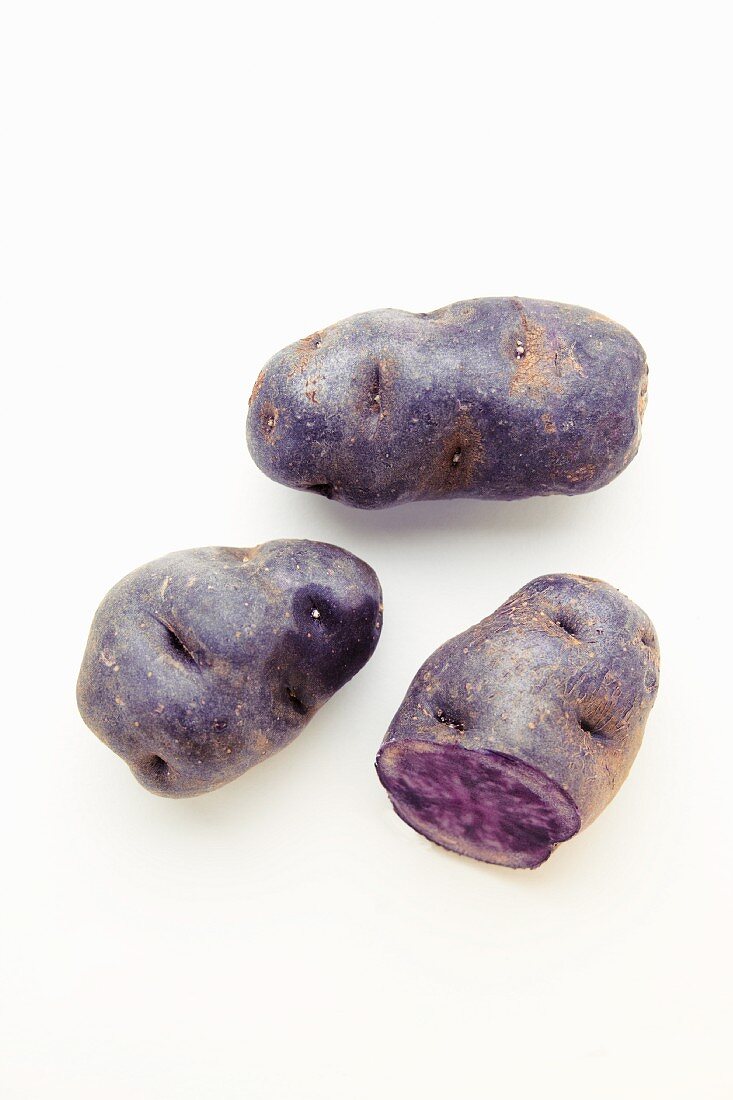 Purple potatoes on a white surface