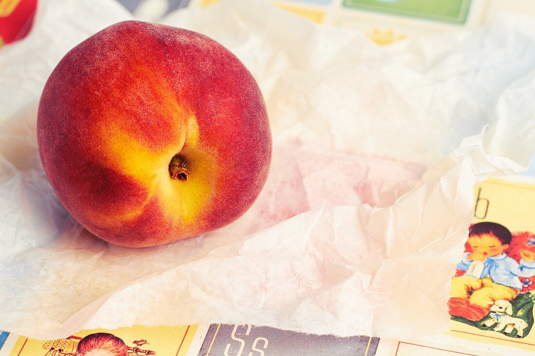 A fresh peach on a piece of white paper