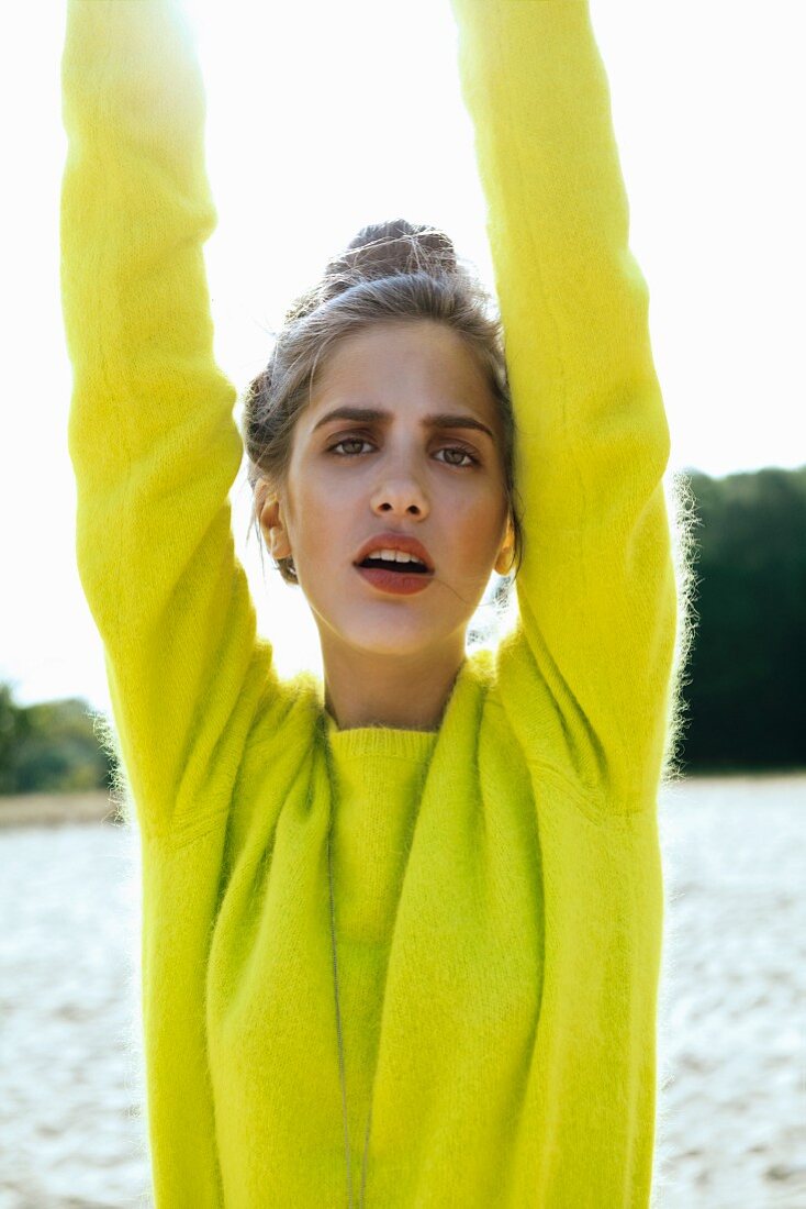 A young woman wearing a neon-yellow angora jumper