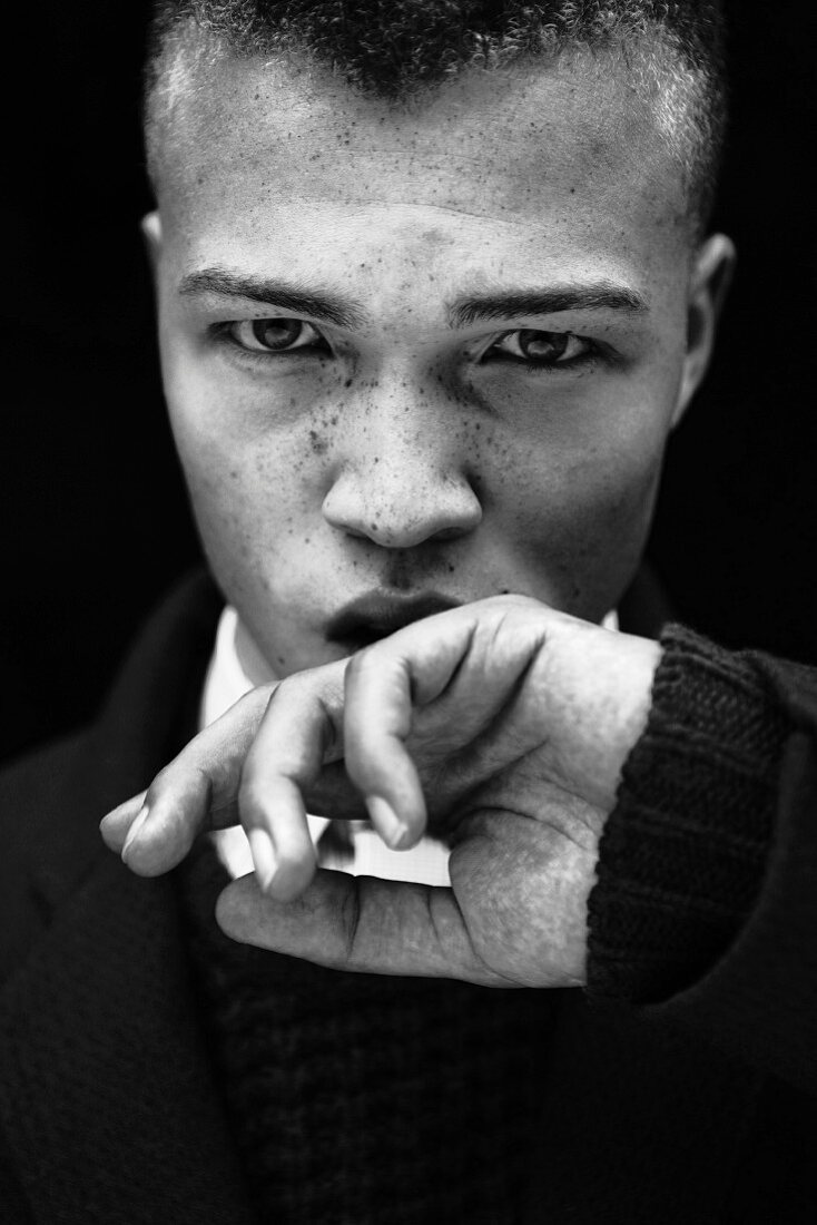 A young man wearing a black woollen jumper (black-and-white shot)