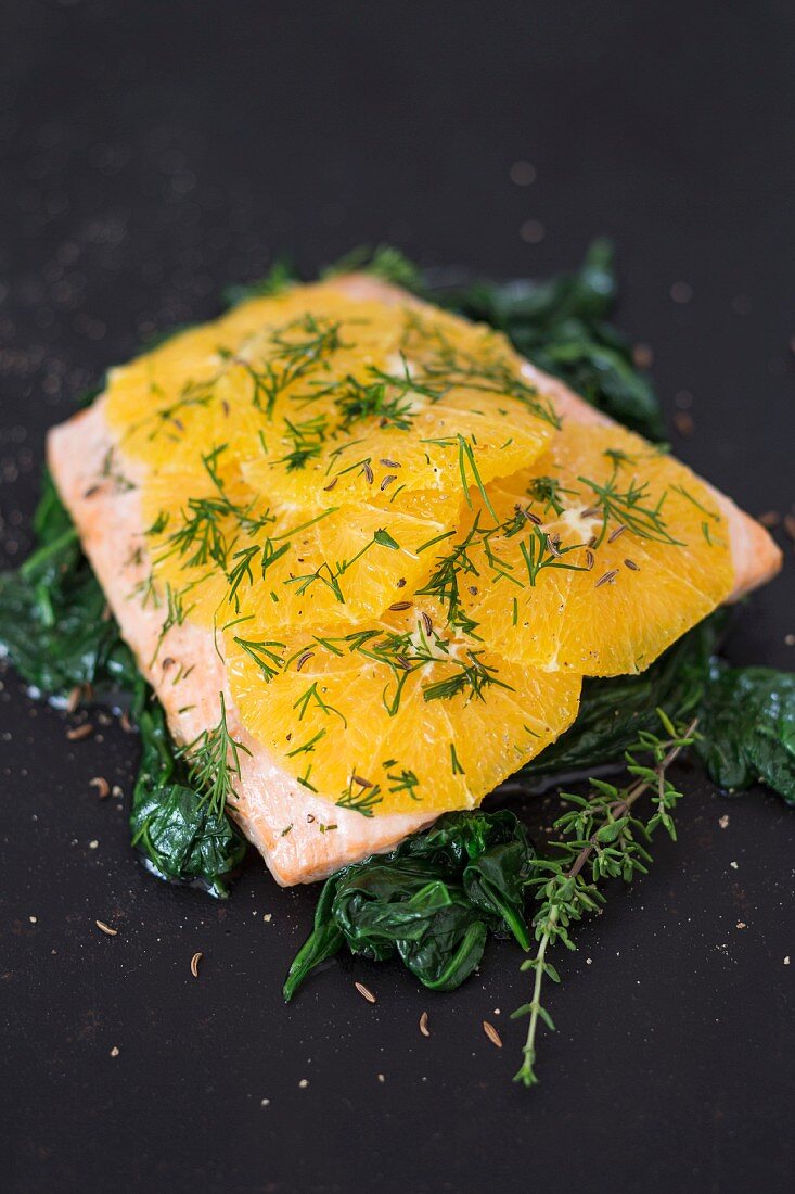 Salmon fillet with oranges and dill on a bed of spinach