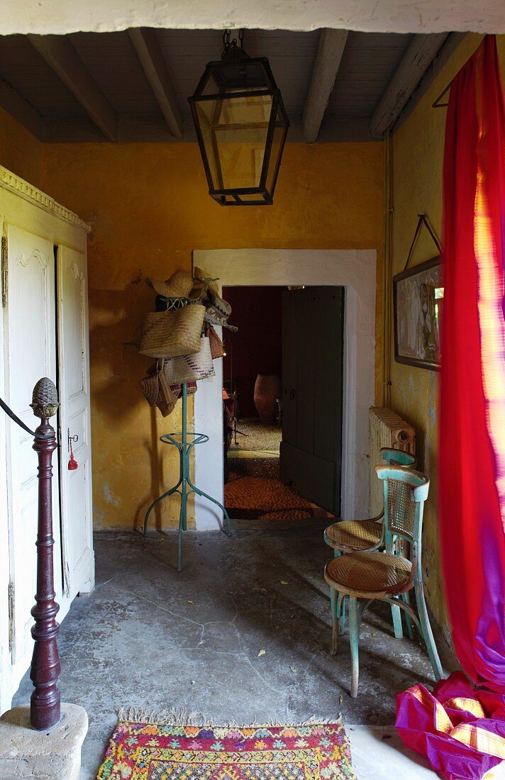 Hausflur mit ockergelb getönten Wänden, an Decke aufgehängte Laterne