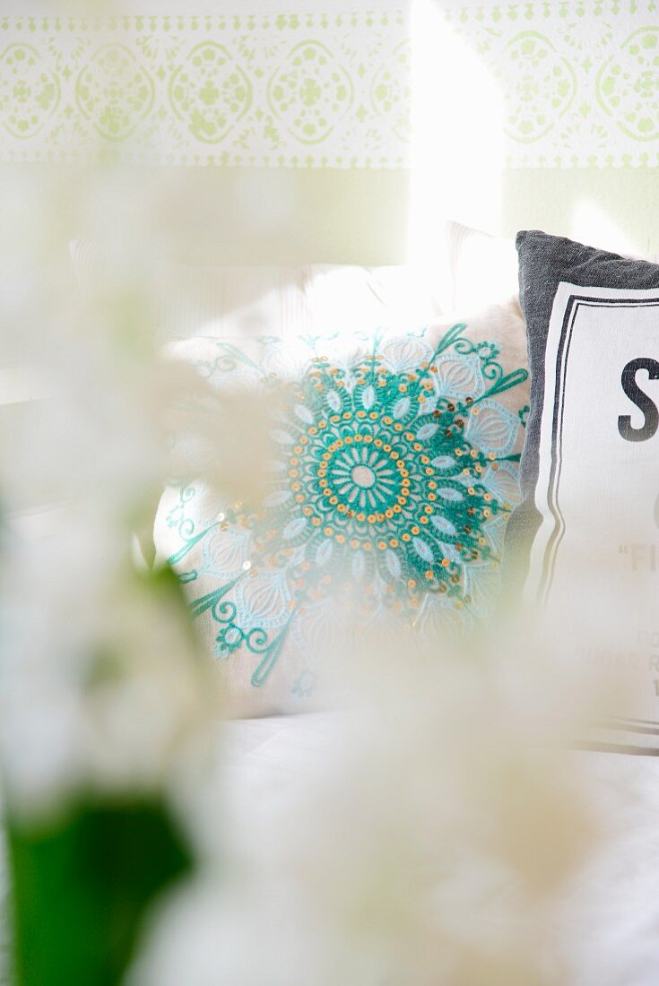 Artistic, turquoise cushion embroidered with sequins in sunshine