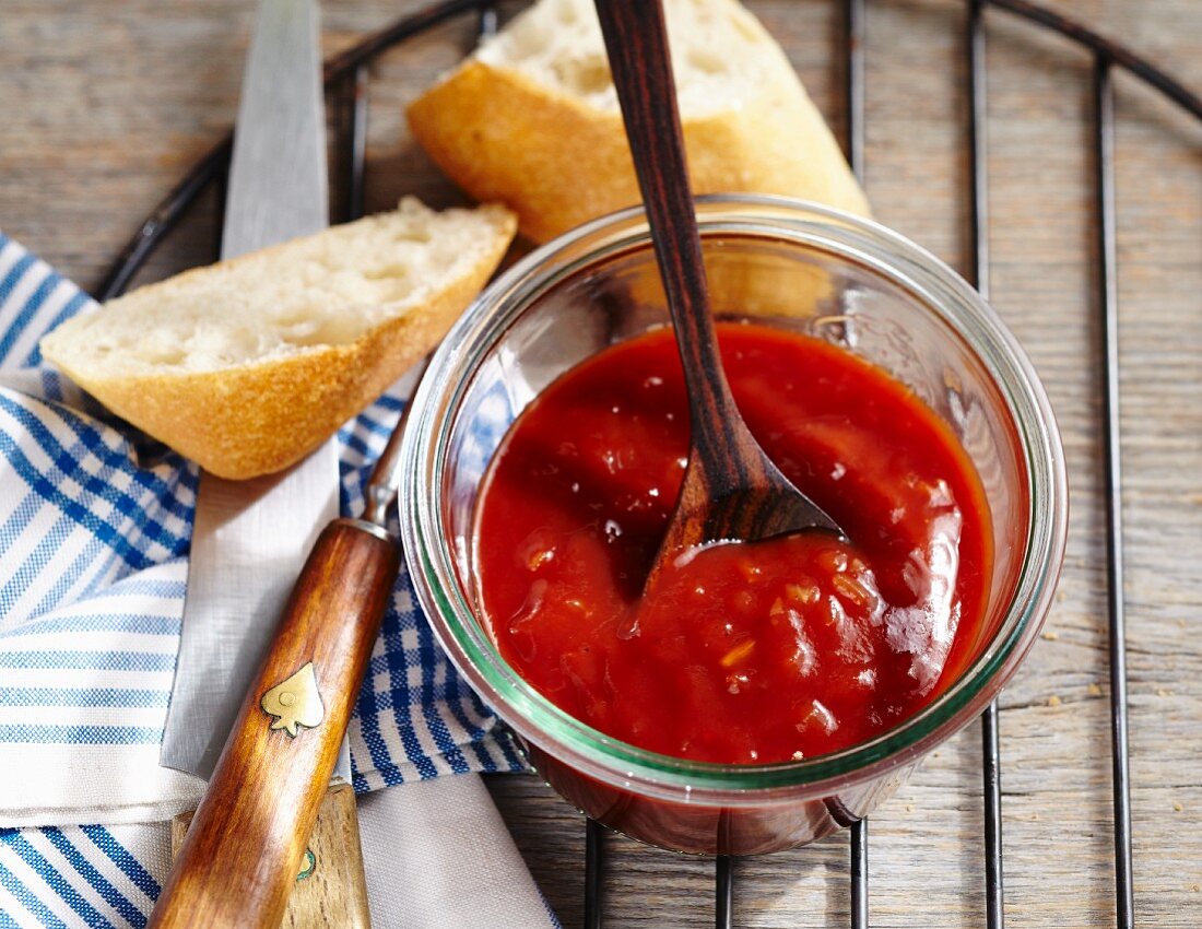 Homemade barbecue sauce in a jar with a spoon