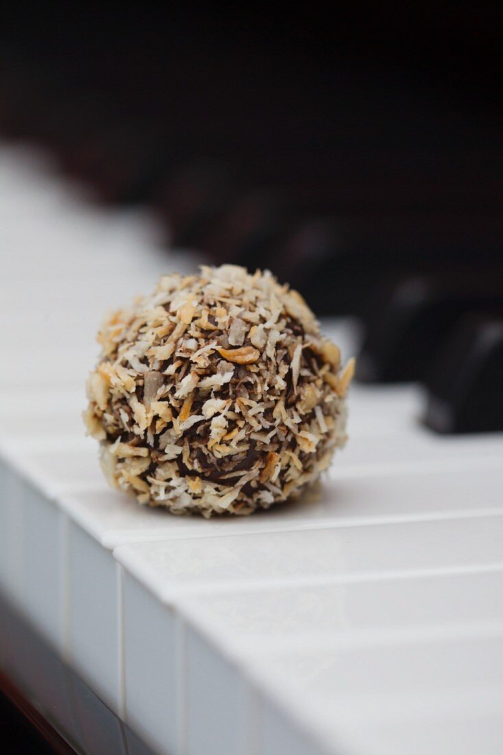 Kokos-Trüffel-Praline auf einer Klaviertastatur