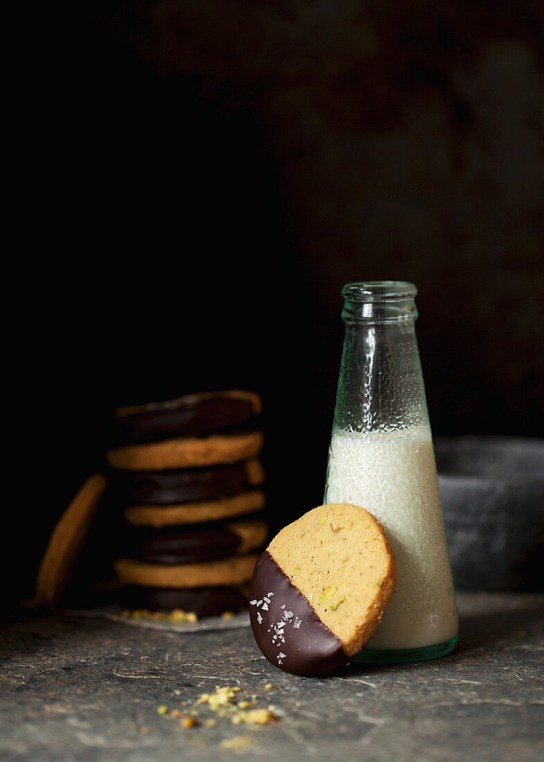 Pistachio biscuits with dark chocolate glaze and sea salt served with a bottle of milk