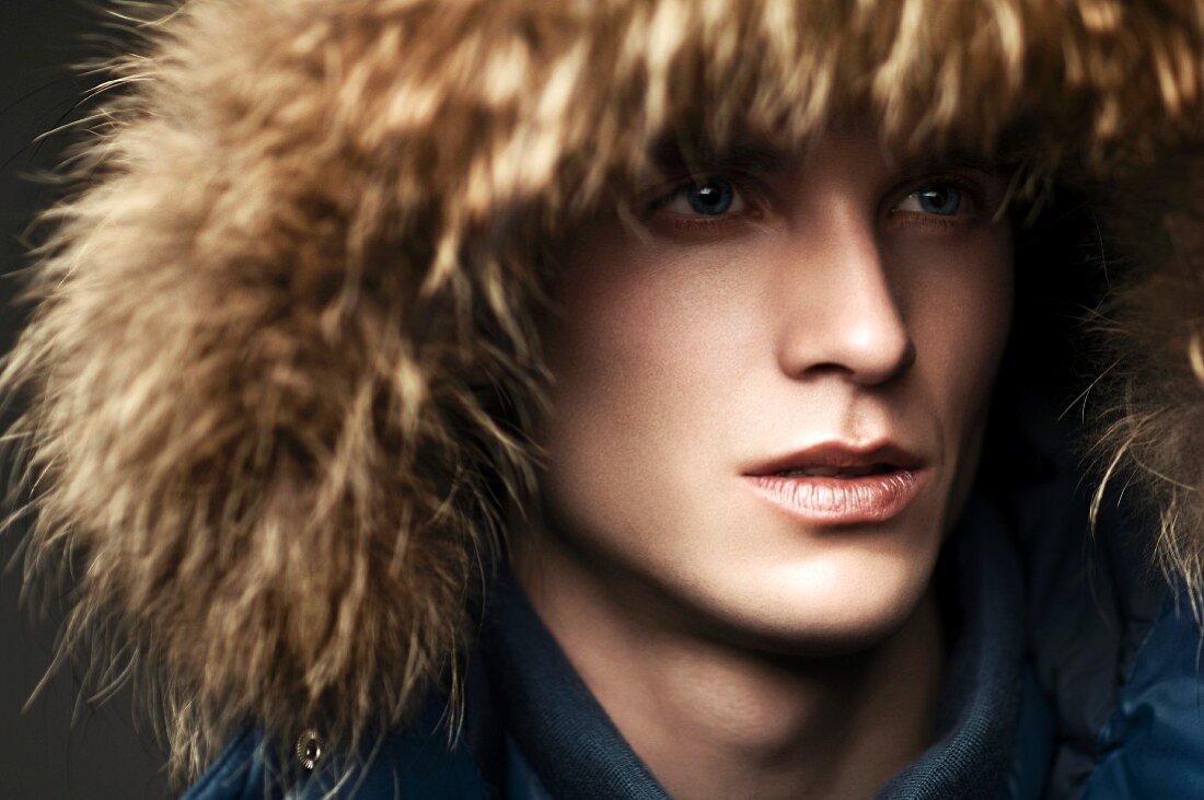 A young man wearing a fur hat