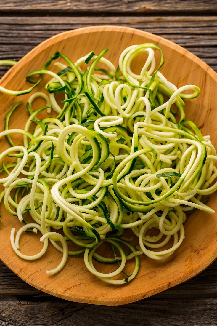 Courgette noodles on a wooden plate