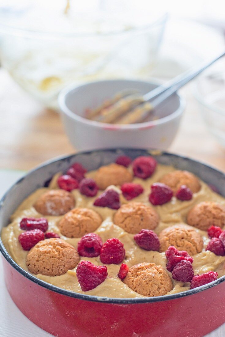 Unbaked amaretti and raspberry cake in a baking dish
