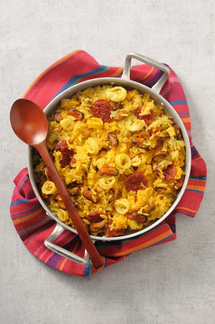 Paella with sausage and squid in a pan