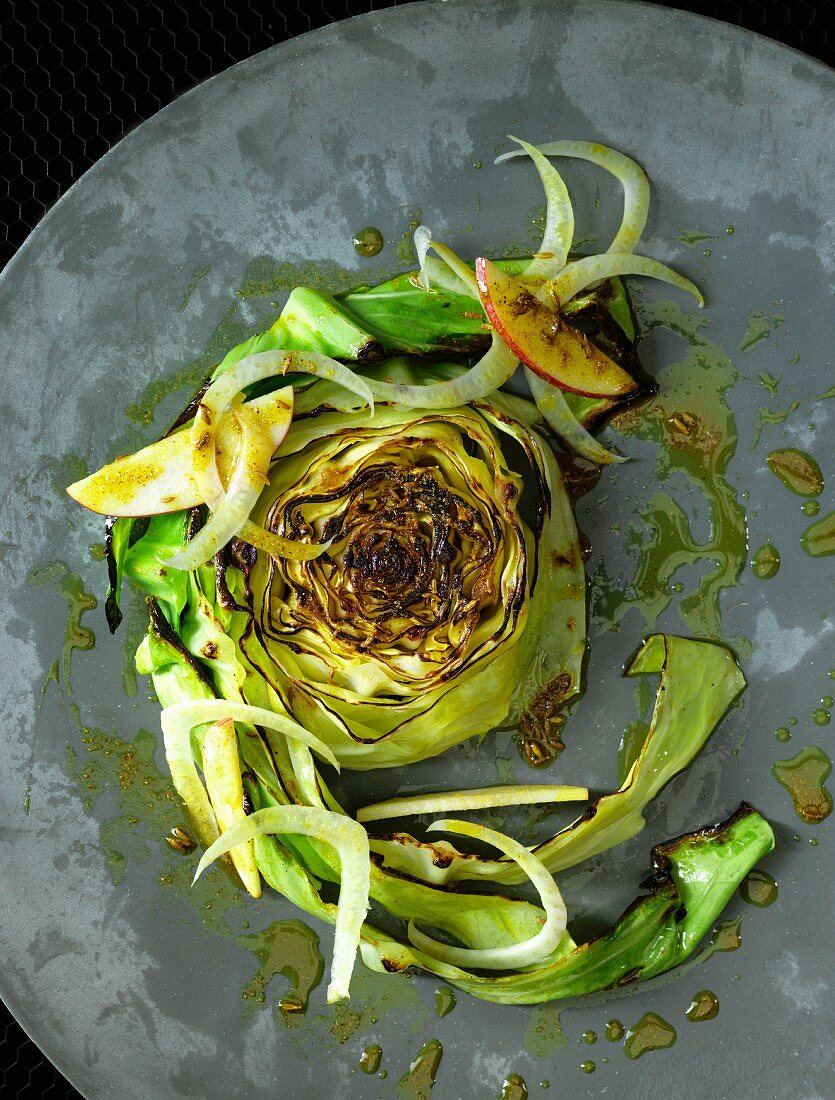 A slice of fried pointed cabbage with fennel and apple in a fennel marinade