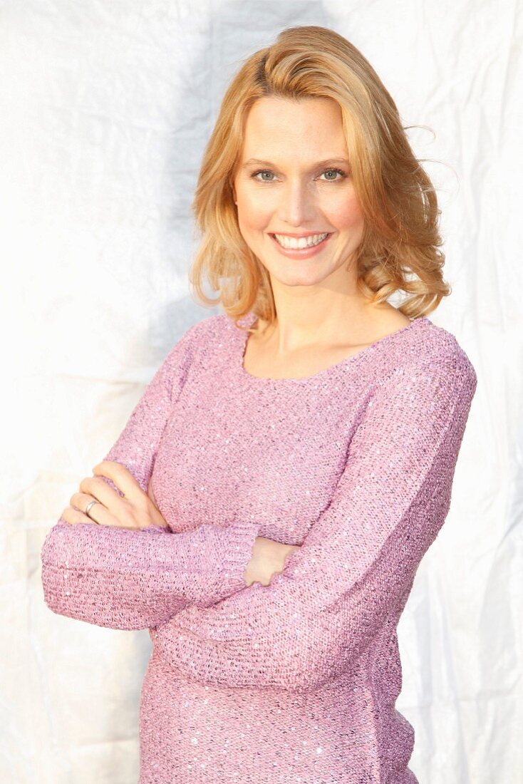 A blonde woman wearing a lilac jumper with Lurex and sequins