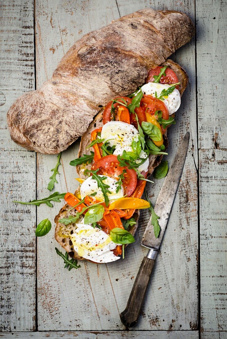 Sandwich mit Mozzarella, Tomaten, Rucola und Basilikum (Italien)